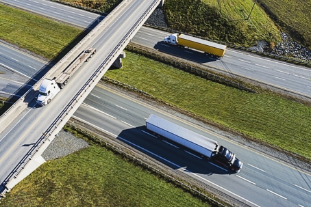 Semi trucks driving on a highway during the day