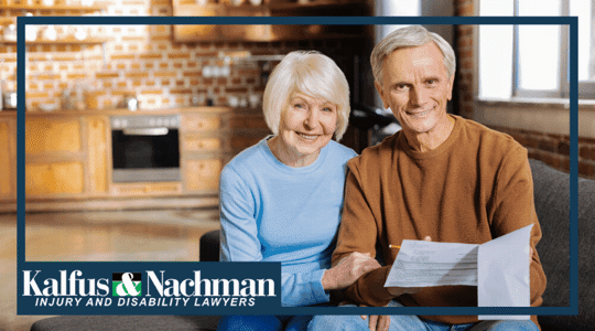 positive elderly couple sitting together and smiling while checking the bills