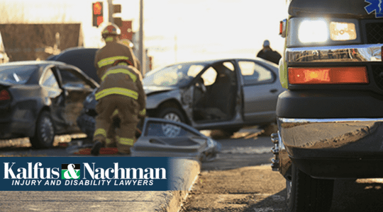 Firefighters in the distance at the scene of a car accident