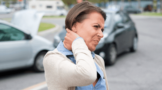woman grabbing her neck from whiplash after a car accident