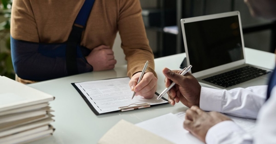 Man with broken arm filling out paperwork