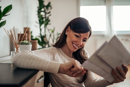 Smiling woman looking at SSD check at home, close-up.