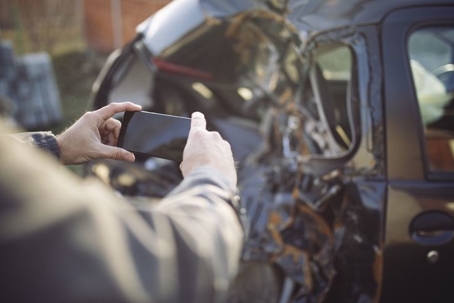 Driver taking picture of car after accident