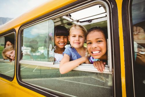 kids looking out school bus window